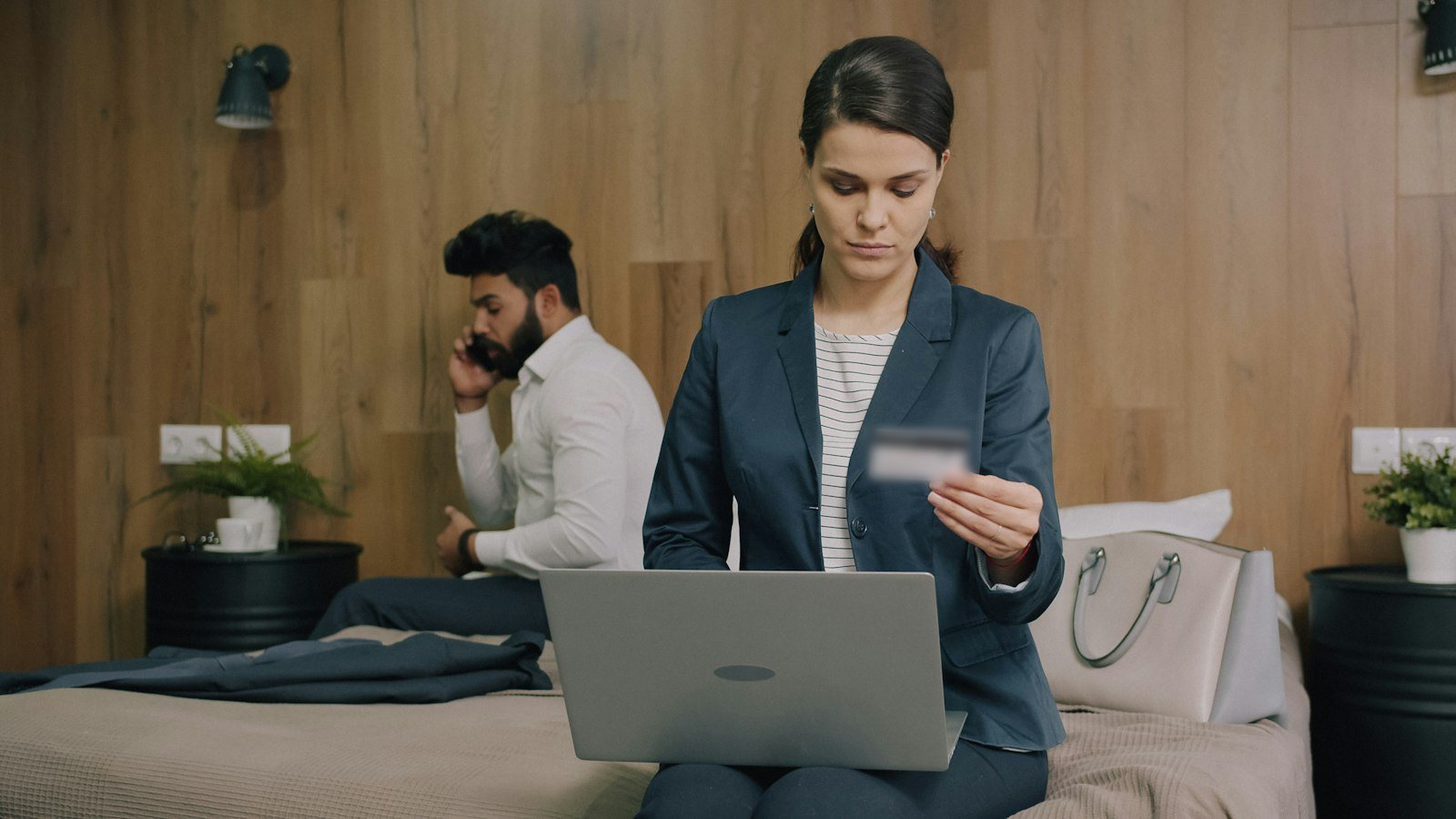 A woman in a blazer shopping online on her laptop with a payment card
